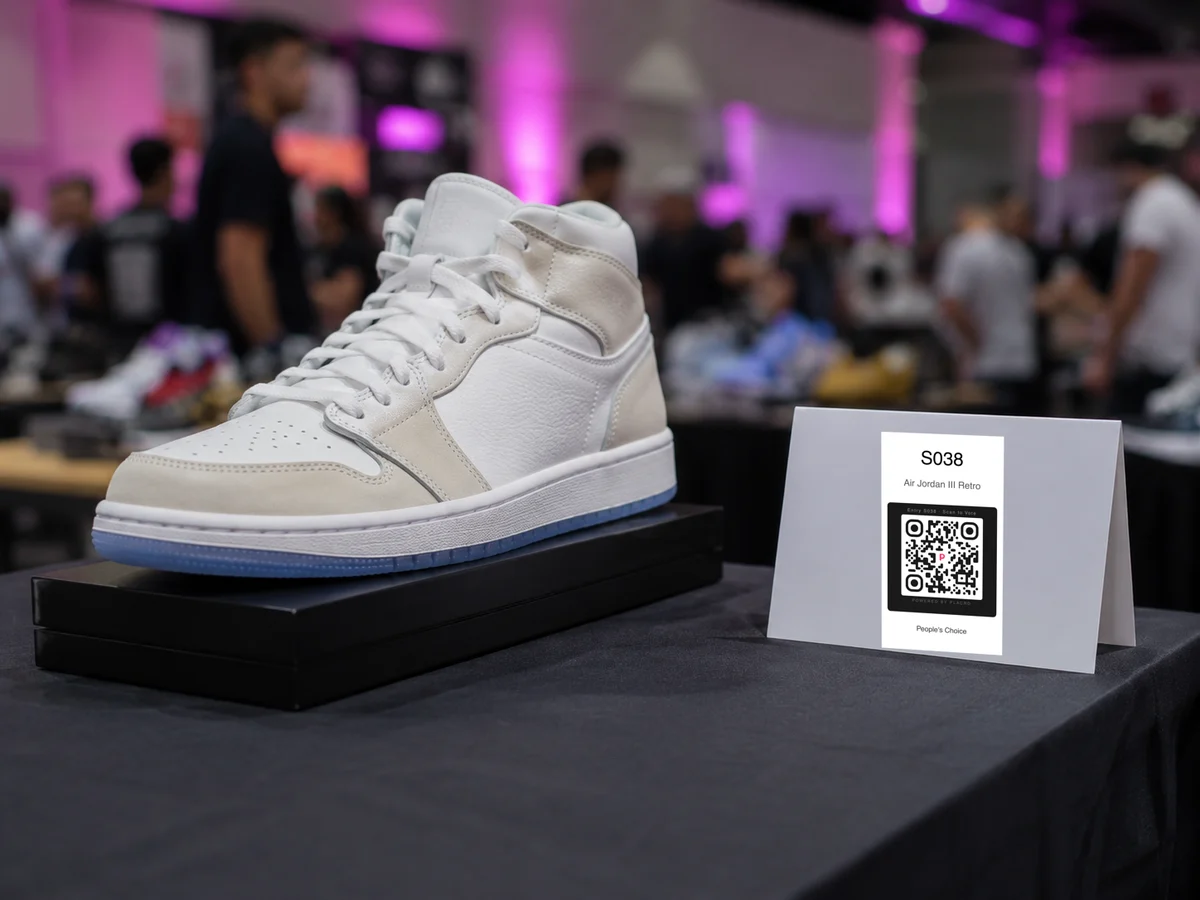 QR voting placard beside a pair of sneakers on a display table at a sneaker meet